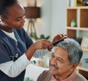 Caregiver combing senior's hair
