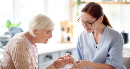 Medical nurse gave a medicine to the elder woman