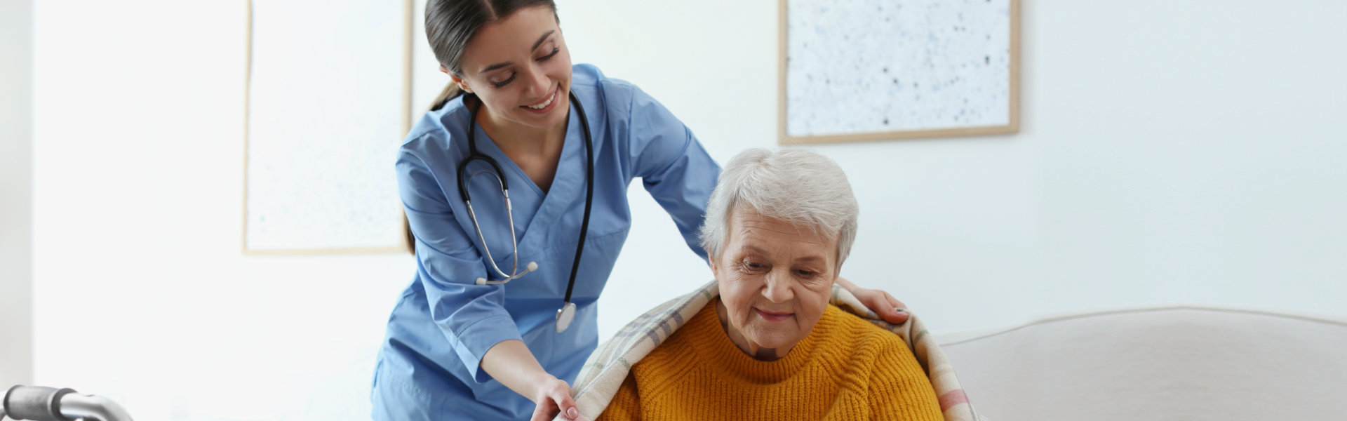 caregiver giving blanket to senior