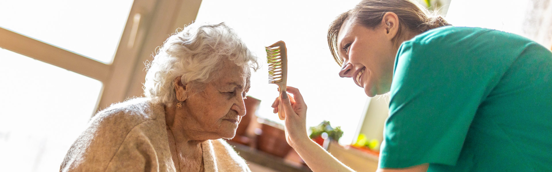 Female nurse comb the hair of the senior woman
