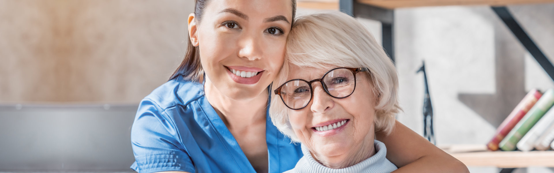 Smiling female nurse and elder woman wearing glasses